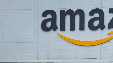 Imagen de un almacén de Amazon y de un letrero con señales de color negro.