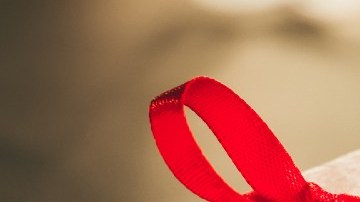 Imagen de varias cajas de regalo con moños de color rojo y verde, sobre fajos de billetes.