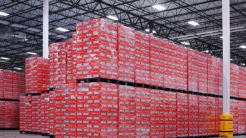 Imagen de cajas de cerveza de color rojas apiladas, en un centro de almacenamiento de la marca Budweiser.