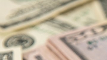 Imagen de varios fajos de billetes de dólar, puestos unos sobre otros.
