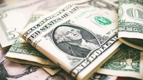 Imagen de varios billetes de dólar unos sobre otros.