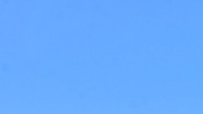 Imagen de un edificio en cuya parte superior hay un letrero con la imagen de la marca Huawei y una antena en la parte superior.