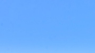 Imagen de un edificio en cuya parte superior hay un letrero con la imagen de la marca Huawei y una antena en la parte superior.