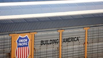 Imagen de un vagón de ferrocarril en color amarillo con letras de color negro.