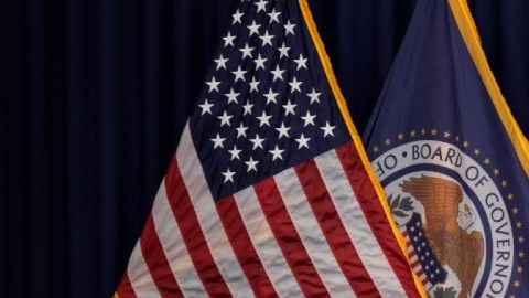 Imagen del presidente de la Fed, Jerome Powell, frente a un estrado y delante de varias banderas de Estados Unidos.
