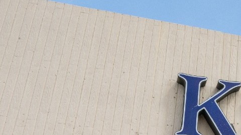 Imagen de la entrada de una tienda Kroger y de una persona que carga mercancía en una camioneta.