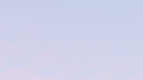 Imagen de un logotipo de la empresa Lyft en color rosa colocado en la fachada de un edificio.