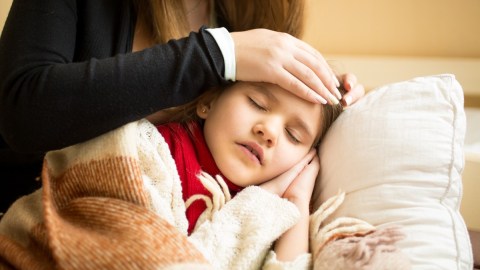 Imagen de una niña enferma con una persona que la acompaña.