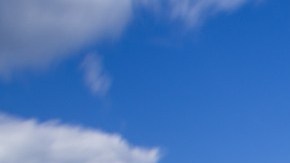 Imagen de dos sillas sobre un muelle frente a un lago.