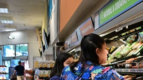 Imagen de dos personas que revisan precios en un supermercado.
