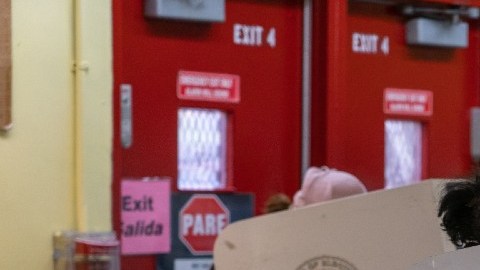 Imagen de varias personas que emiten su voto en casillas cerradas de votación.