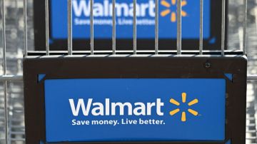 Imagen de un logotipo en color azul de la marca Walmart, en una placa de plástico en un carrito de supermercado.