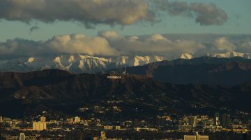 Snow-topped mountains stand behind the Los Angeles downtown skyline after sunrise following heavy rains as seen from the Kenneth Hahn State Recreation Area on December 29, 2020 in Los Angeles, California. (Photo by Patrick T. FALLON / AFP) (Photo by PATRICK T. FALLON/AFP via Getty Images)