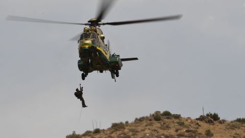 A member of law enforcement is hoisted up to a Los Angeles Sheriff Department (LASD) Rescue 5 Super Puma helicopter near the house of a suspected gunman of a shooting at a fire station on June 1, 2021 in Acton, California. - A shooting at a fire station in Agua Dulce on Tuesday morning left one firefighter dead and another wounded, officials said. (Photo by Patrick T. FALLON / AFP) (Photo by PATRICK T. FALLON/AFP via Getty Images)