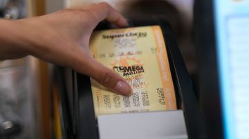 A cashier prints out a Mega Millions lottery ticket at a 7-Eleven convenience store in Chino Hills, California, July 28, 2022. - The odds of claiming this week's bonanza US lottery prize are less than one-in-300-million -- but one "lucky" convenience store outside Los Angeles is already counting its winnings. A sign above the counter of the otherwise unassuming shop in California's Chino Hills proclaims itself the "LUCKIEST 7-ELEVEN IN THE WORLD," six years after it sold a winning ticket for the largest jackpot in US lottery history. (Photo by RINGO CHIU / AFP) (Photo by RINGO CHIU/AFP via Getty Images)