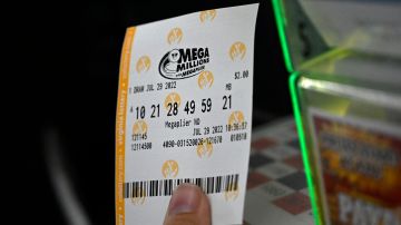 A person buys a Mega Millions lottery ticket at a store on July 29, 2022 in Arlington, Virginia. - The jackpot for Friday's Mega Millions is now $1.1 billion, the second-largest jackpot in game history. (Photo by OLIVIER DOULIERY / AFP) (Photo by OLIVIER DOULIERY/AFP via Getty Images)