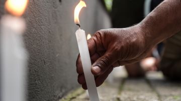 SAO PAULO, BRAZIL - DECEMBER 04: A person lights a candle as fans hold a vigil in support of football legend Pele who remains hospitalized due to a respiratory infection amid ongoing colon cancer treatments at Albert Einstein Israeli Hospital on December 4, 2022 in Sao Paulo, Brazil. (Photo by Mauro Horita/Getty Images)