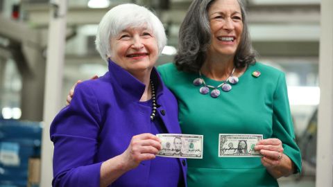 La secretaria del Tesoro Janet Yellen y la tesorera, Marilynn Malerba, sostienen dólares con sus firmas.