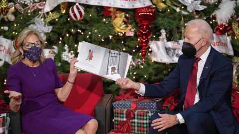 Joe Biden sostiene el libro mientras Jill Biden se lo lee a los niños.