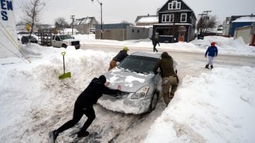 Los buenos samaritanos ayudan a sacar un automóvil a lo largo de South Park Avenue el 27 de diciembre de 2022 en Buffalo, Nueva York