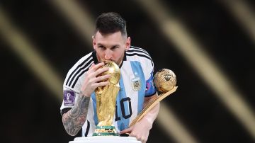 Lionel Messi con el Balón de Oro del Mundial de Qatar y besando la Copa del Mundo.