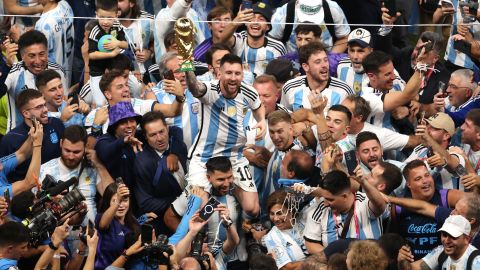 Lionel con la Copa del Mundo en Qatar 2022 encima de Sergio 'Kun' Agüero.