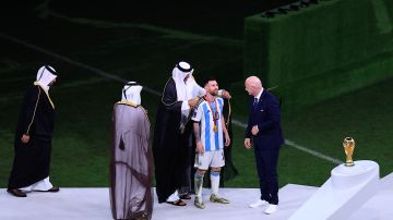 Lionel Messi recibe el bisht de la mano de Hamad Al Thani.