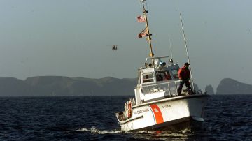 ANACAPA ISLAND, UNITED STATES: A US Coast Guard sailor and helicopter search for survivor and debris 01 February, 2000 of Alaskan Airlines flight 261 that crashed off the coast of southern California near Anacapa Island. No survivors have been found of the 88 passengers and crew aboard the airliner heading to San Francisco from Puerto Vallarta, Mexico. (ELECTRONIC IMAGE) AFP PHOTO/Mike NELSON (Photo credit should read MIKE NELSON/AFP via Getty Images)