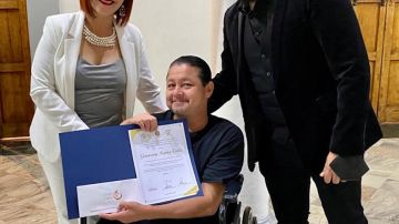 Michael Dergar, fundador de la Fundación de la Academia de Sueños Especiales de Los Ángeles dirigida por el artista Michael Dergar entrega una silla de ruedas al artista  Geowwanny Ivanhoe Valdez. (Cortesía)
