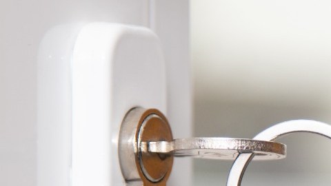 Imagen de una chapa en la que se ve un llavero con forma de una casa y una llave.