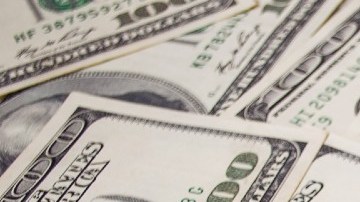 Muchos billetes de $100 dólares colocados unos sobre otros.