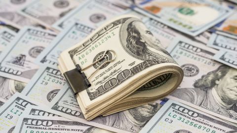 Imagen de fajos de billetes de dólares.