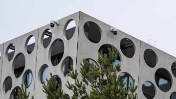 Imagen de un muñeco gigante de Lego frente a un edificio corporativo.