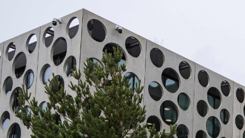 Imagen de un muñeco gigante de Lego frente a un edificio corporativo.
