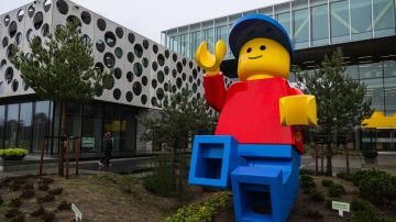 Imagen de un muñeco gigante de Lego frente a un edificio corporativo.