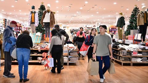 Imagen de varias personas que cargan bolsas de compras en una tienda.