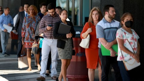 Imagen de varias personas formadas en una feria de trabajo.