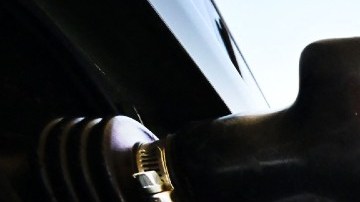 Imagen de una toma de gasolina que carga combustible en un auto.