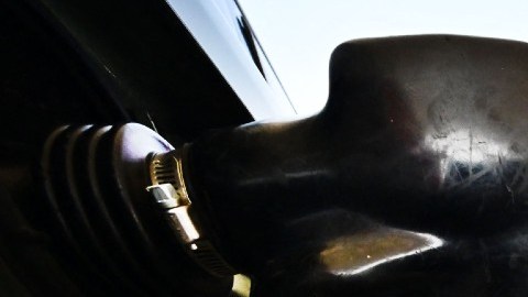 Imagen de una toma de gasolina que carga combustible en un auto.