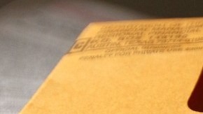 Imagen de un cheque de reembolso de impuestos de color verde y un sobre color amarillo.