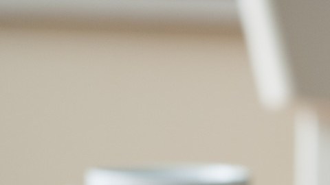 Imagen de un vaso lleno de billetes, junto con una calculadora y unos lentes.