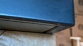 Imagen de un vaso de Starbucks que están colocado sobre una barra de entrega de madera y en la que se ve un letrero de promoción del programa Starbucks Rewards.