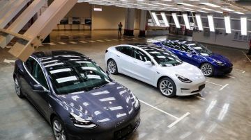 Imagen de tres vehículos Tesla Model 3 de colores gris, blanco y azul.