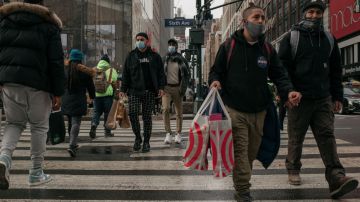 Imagen de personas caminando en la calle con bolsas de compras.