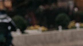 Imagen de una persona que carga bolsas de compras mientras cruza una calle.