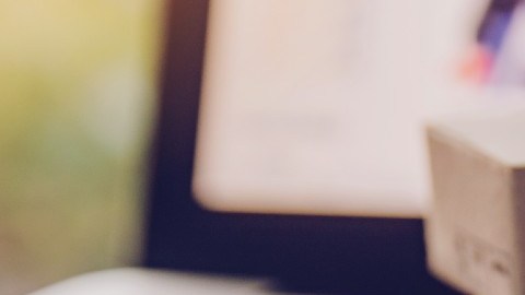 Imagen de varias cajas en miniatura que están colocadas sobre el teclado de una computadora y junto a una tarjeta bancaria.