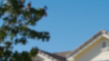 Imagen de una casa que tiene un letrero de venta en el jardín delantero.