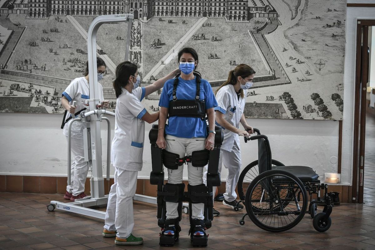 Enfermeras instalan un exoesqueleto de Wandercraft a una médico antes de una demostración en el hospital de los Inválidos de París.