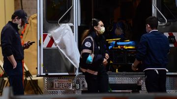 Paramedics wearing facemasks work behind an ambulance at the Garfield Medical Center in Monterey Park, California on March 19, 2020. - All residents of California were ordered to stay at home March 19, 2020, in a bid to battle the coronavirus pandemic in the most populous state in the US. Los Angeles residents were ordered to stay at home by the city's mayor Eric Garcetti on Thursday in a bid to battle the coronavirus pandemic. (Photo by Frederic J. BROWN / AFP) (Photo by FREDERIC J. BROWN/AFP via Getty Images)