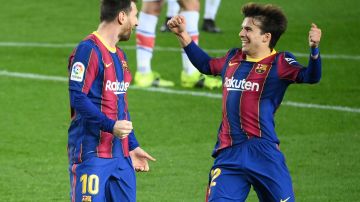 Messi (I) celebra un gol junto a Puig( D)